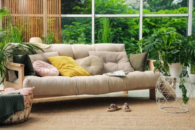 Photo of Indoor terrace interior with comfortable sofa and green plants