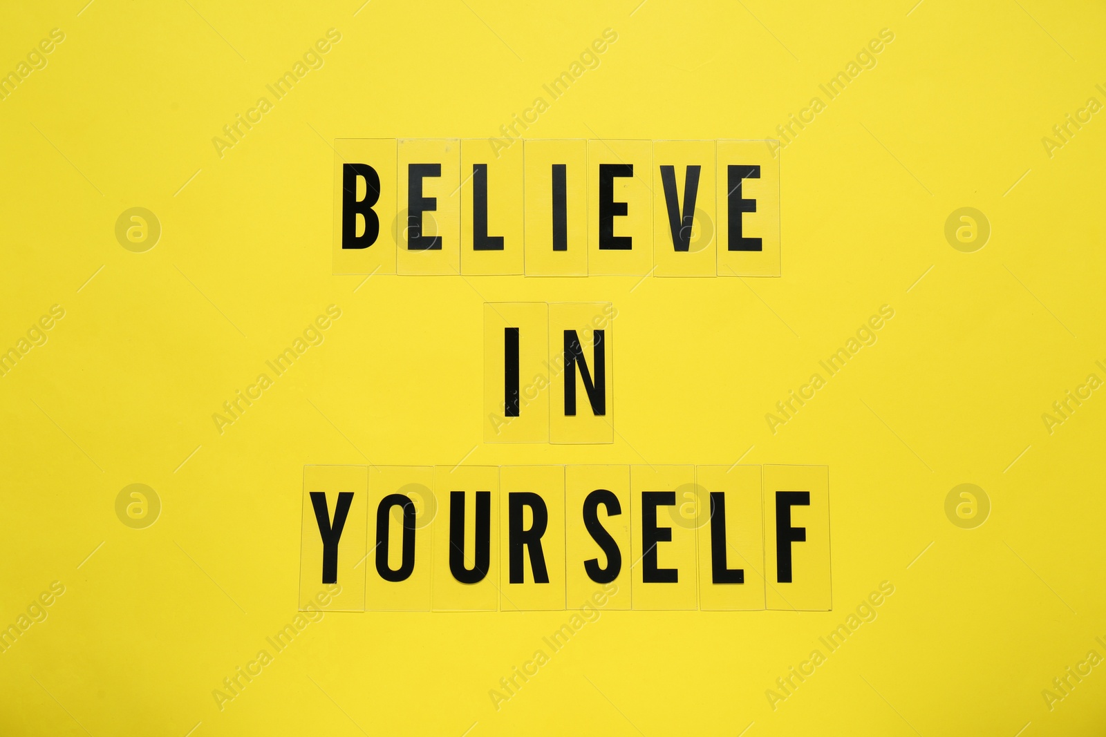 Photo of Phrase Believe In Yourself and hearts on yellow background, top view. Motivational quote