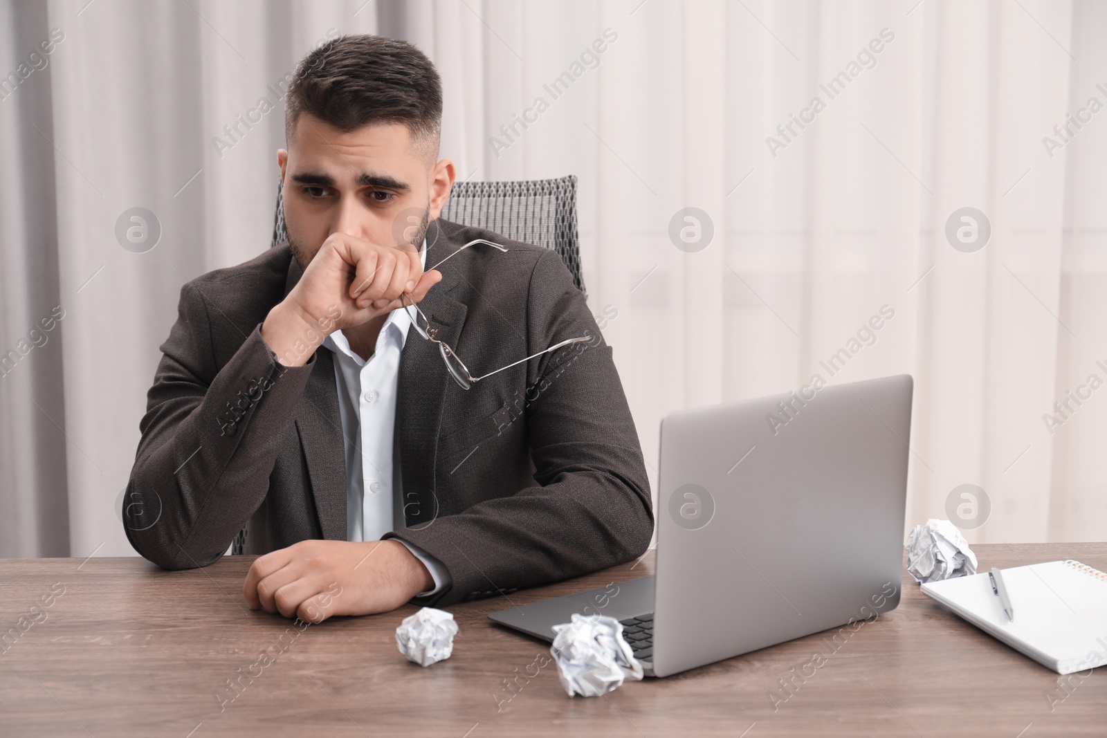 Photo of Sad businessman sitting at table in office