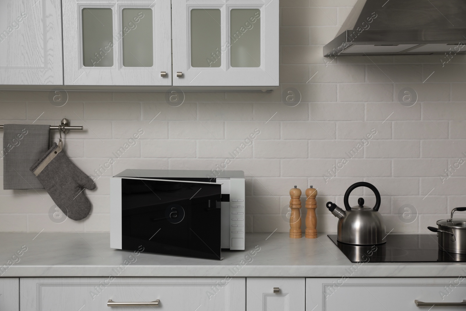 Photo of Modern microwave oven on countertop in kitchen