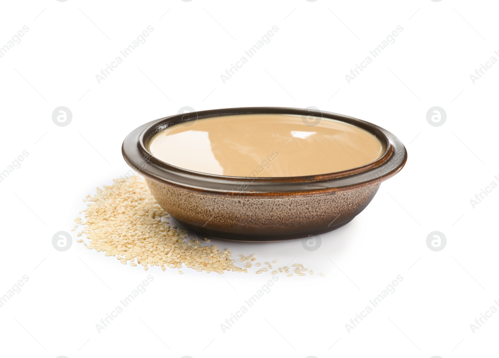 Photo of Tasty sesame paste in bowl and seeds on white background