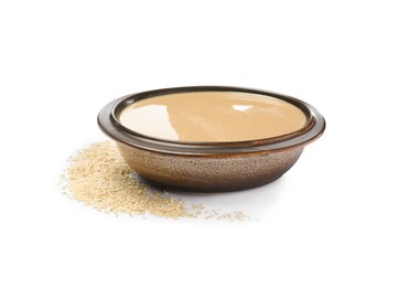 Photo of Tasty sesame paste in bowl and seeds on white background