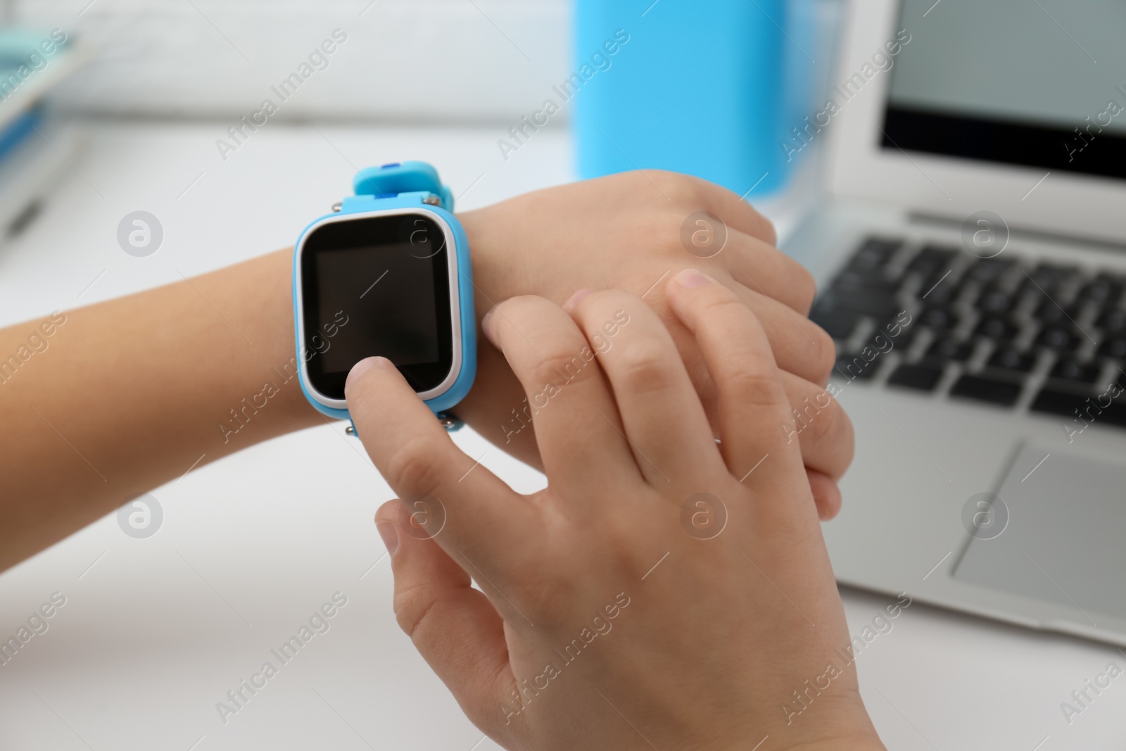 Photo of Boy with stylish smart watch at white table, closeup