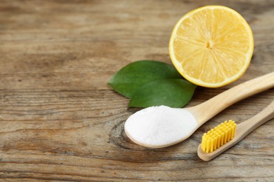 Photo of Bamboo toothbrush, lemon and spoon of baking soda on wooden table, space for text