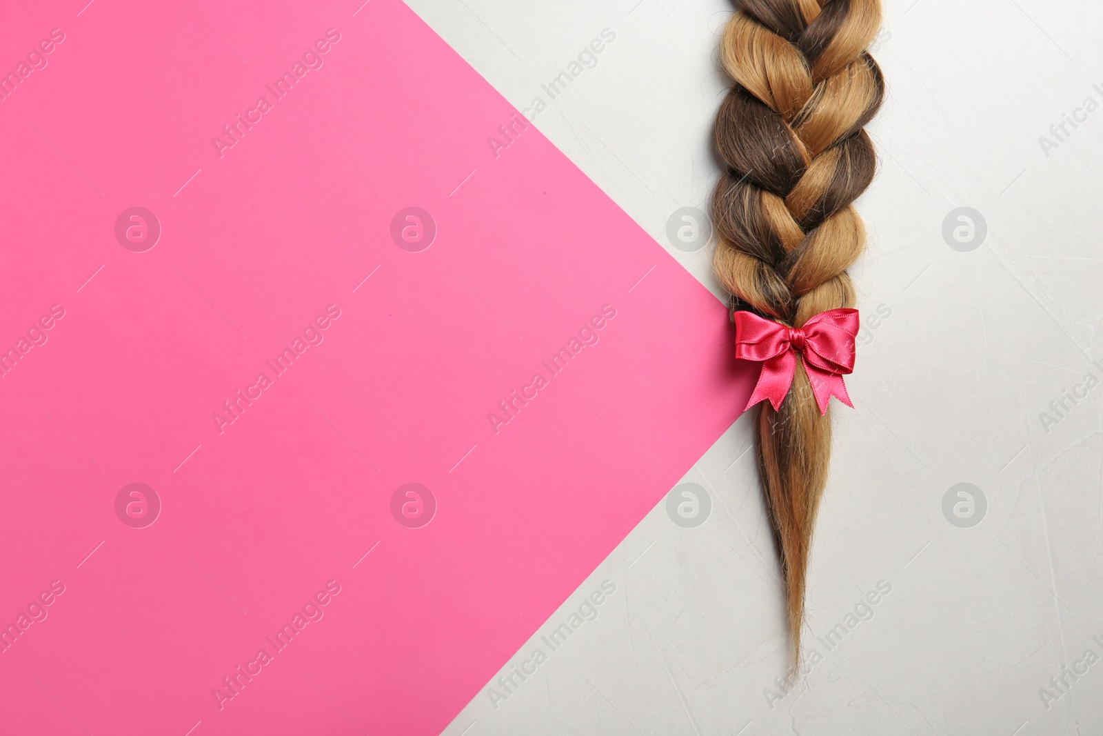 Photo of Braid and space for text on color background, top view. Healthy hair