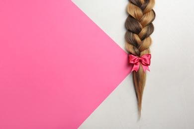 Braid and space for text on color background, top view. Healthy hair