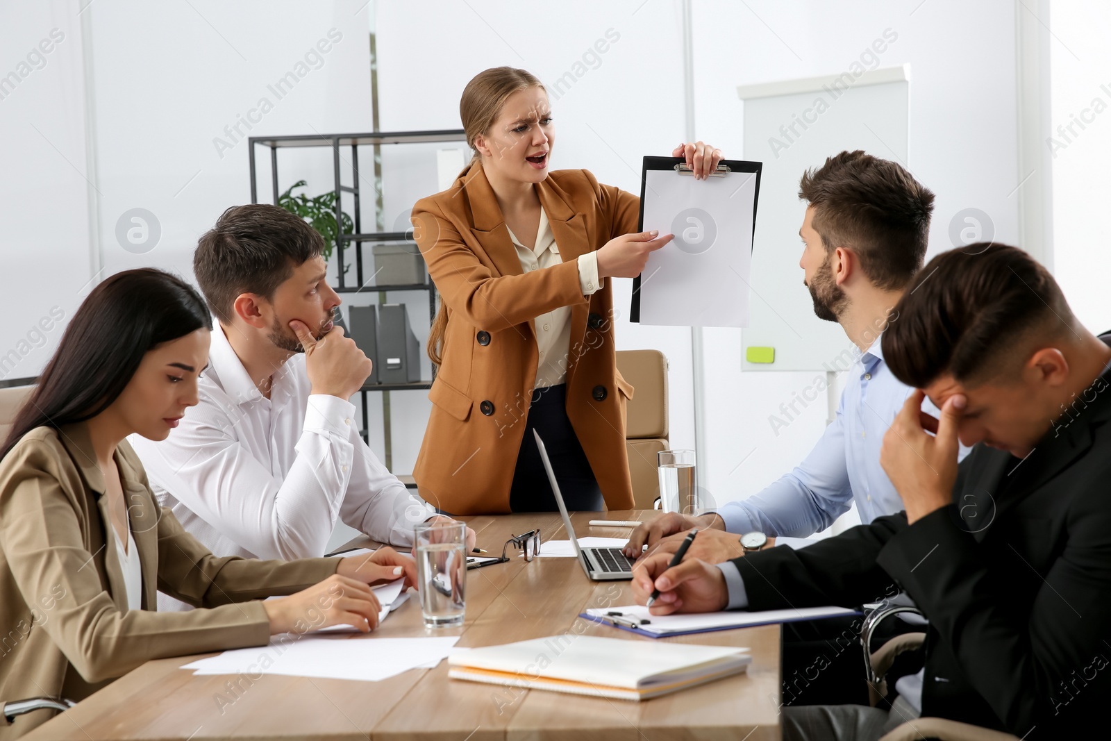 Photo of Boss screaming at employees in office. Toxic work environment