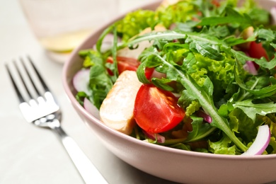 Delicious salad with chicken, arugula and tomatoes on table, closeup