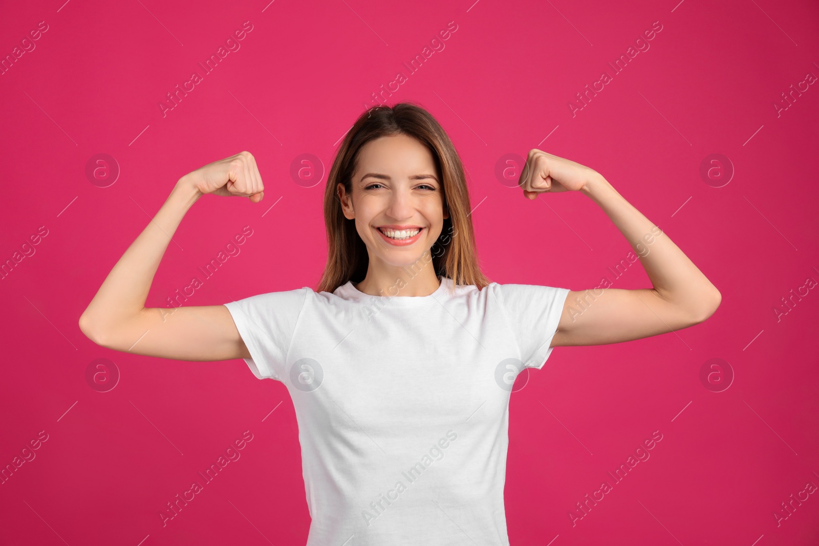 Photo of Strong woman as symbol of girl power on pink background. 8 March concept
