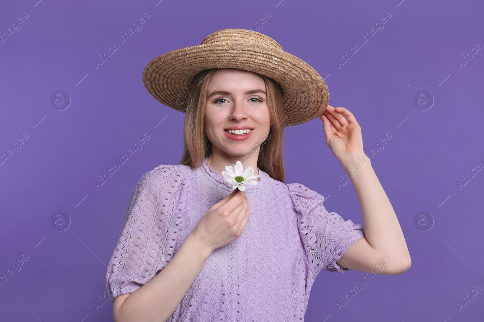 Photo of Beautiful woman with spring flower in hand on purple background