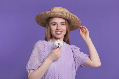 Beautiful woman with spring flower in hand on purple background