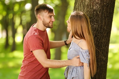 Happy young couple in green park on sunny spring day