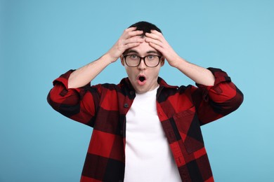 Photo of Surprised man in glasses on light blue background