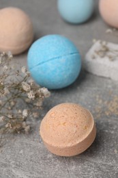 Beautiful aromatic bath bombs and gypsophila flowers on light grey table