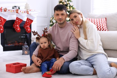 Photo of Happy family in room decorated for Christmas