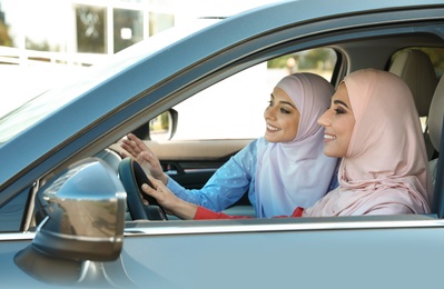 Female Muslim driver and her friend in car