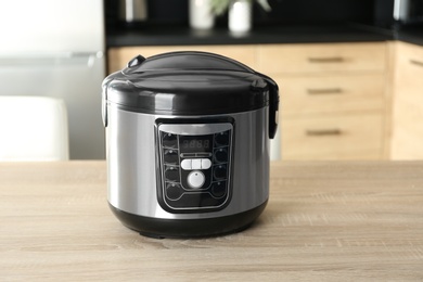 Modern multi cooker on wooden table in kitchen