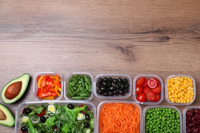 Set of plastic containers with fresh food on wooden  table, flat lay. Space for text