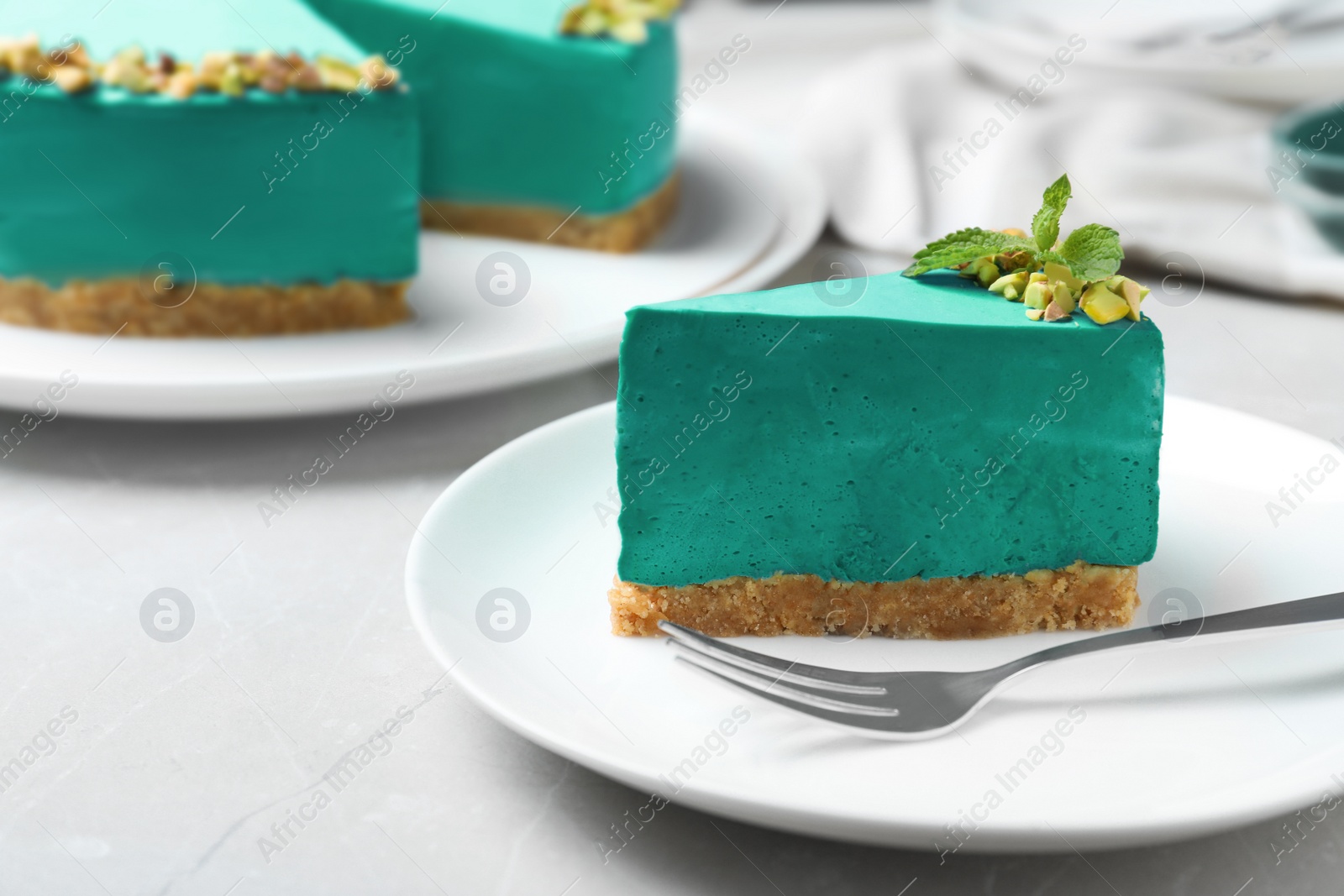 Photo of Delicious homemade spirulina cheesecake served on light table