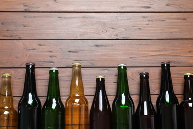 Photo of Bottles with different types of beer on wooden background