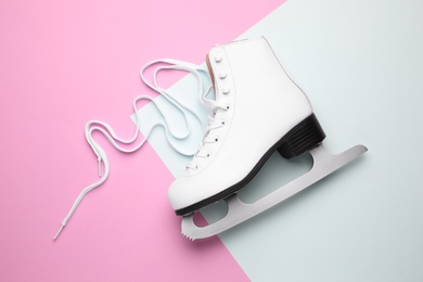 Photo of Pink ice skate on color background, top view
