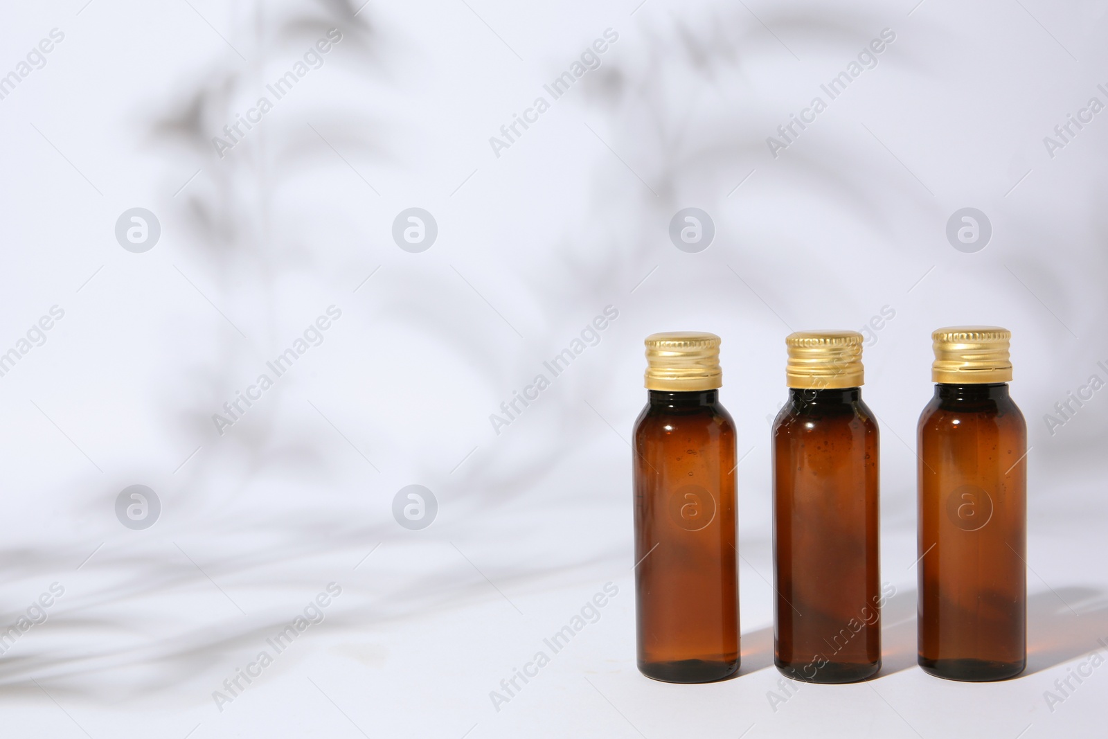 Photo of Bottles of cosmetic products on white background. Space for text