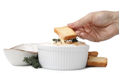 Photo of Woman dipping crouton into tasty baked camembert on white background, closeup