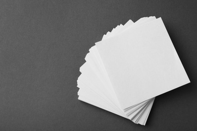 Photo of Blank note papers on dark grey background, top view. Mock up for design