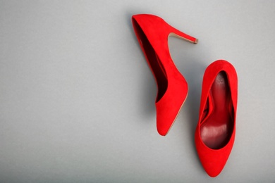 Pair of female shoes on color background