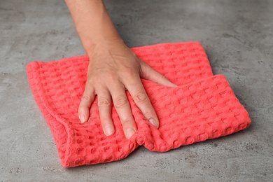 Woman wiping stone surface with kitchen towel, closeup