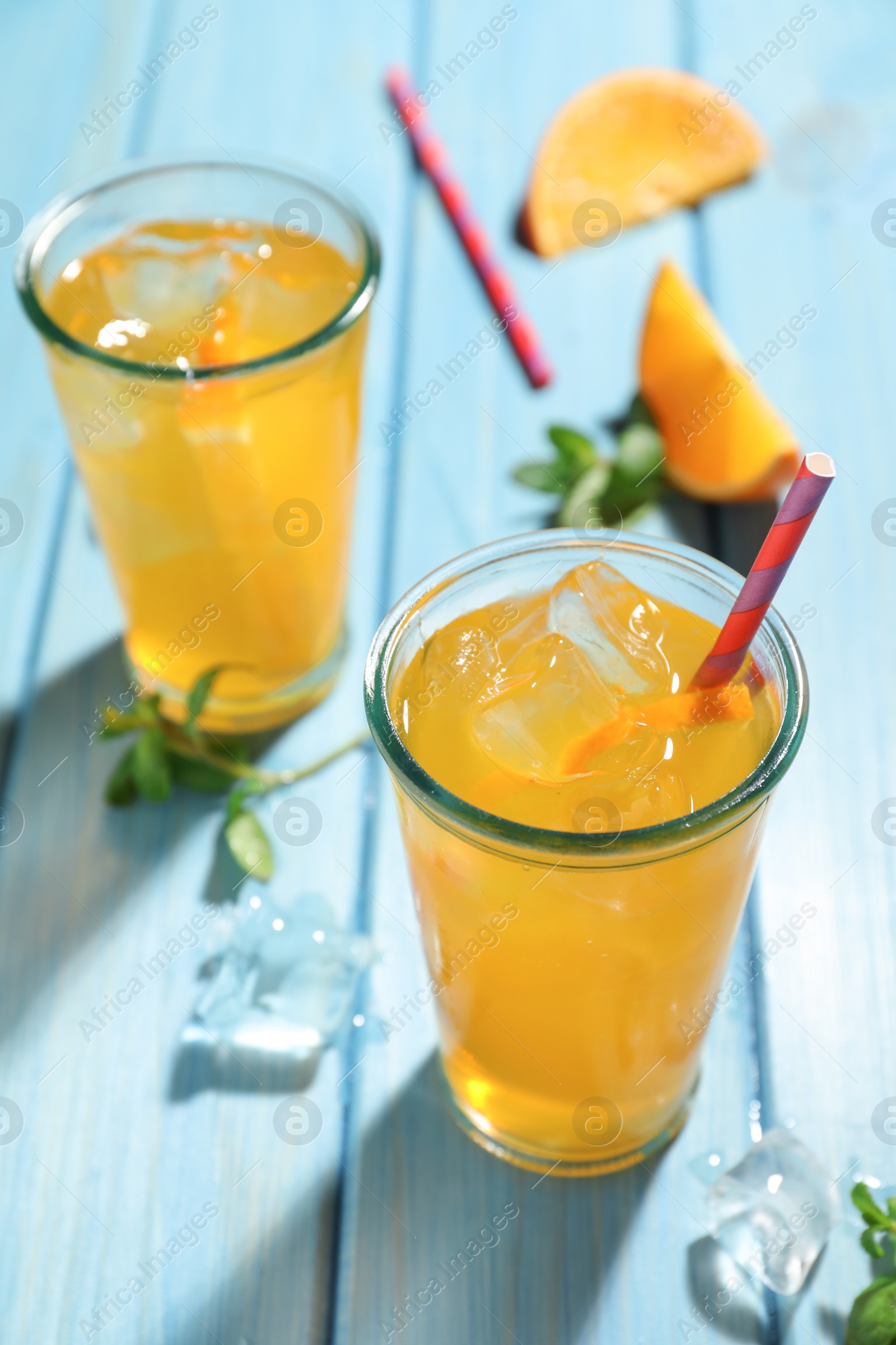 Photo of Delicious orange soda water on light blue wooden table