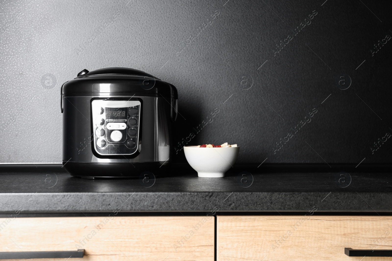 Photo of Modern multi cooker and ingredients on table in kitchen, space for text