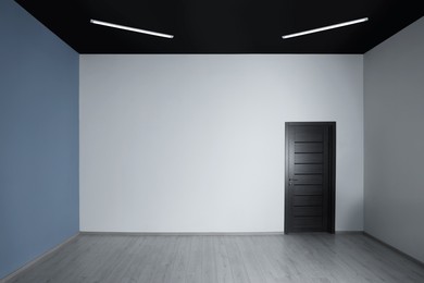 Photo of Empty renovated room with white walls and black door