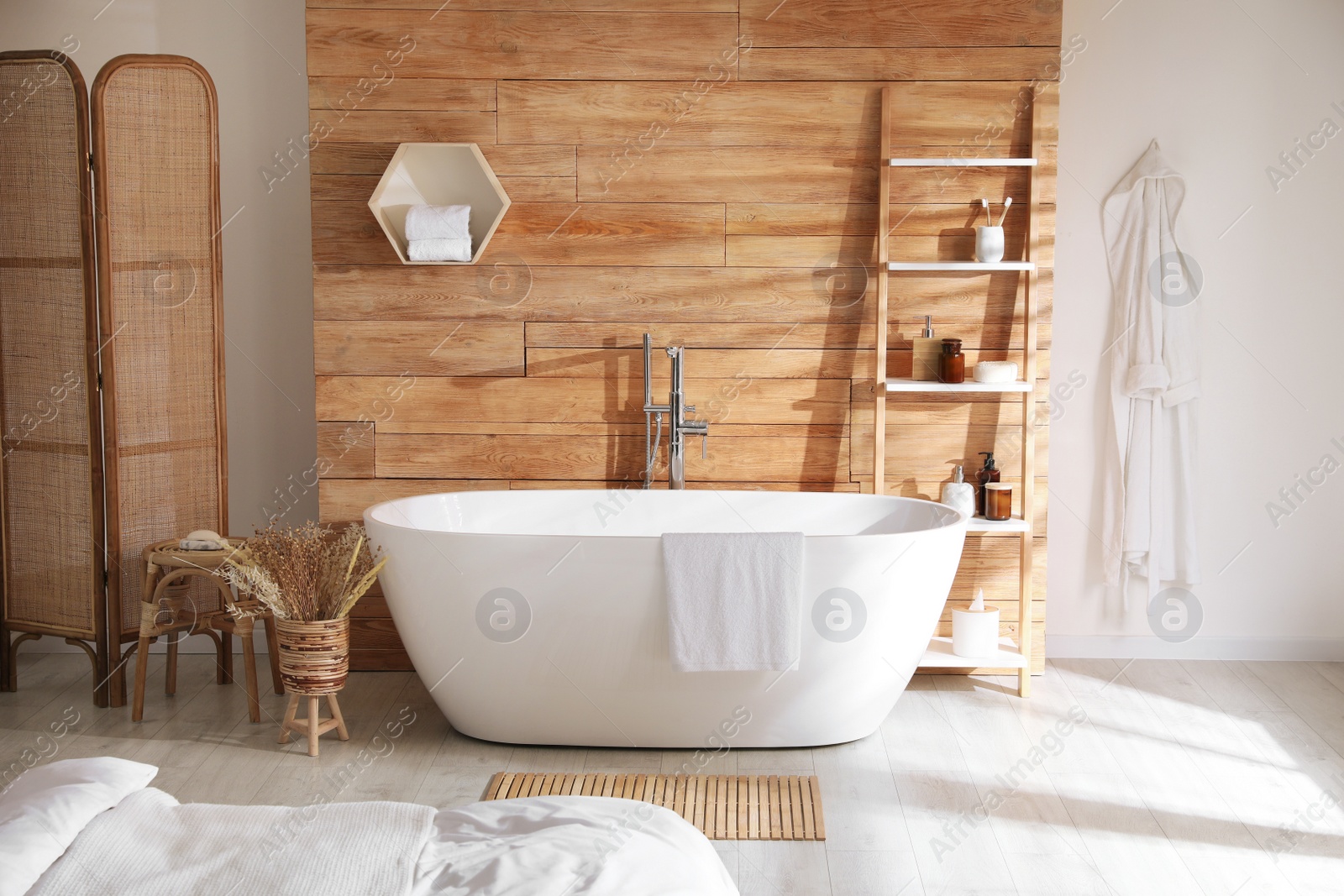 Photo of Stylish apartment interior with white bathtub and bed