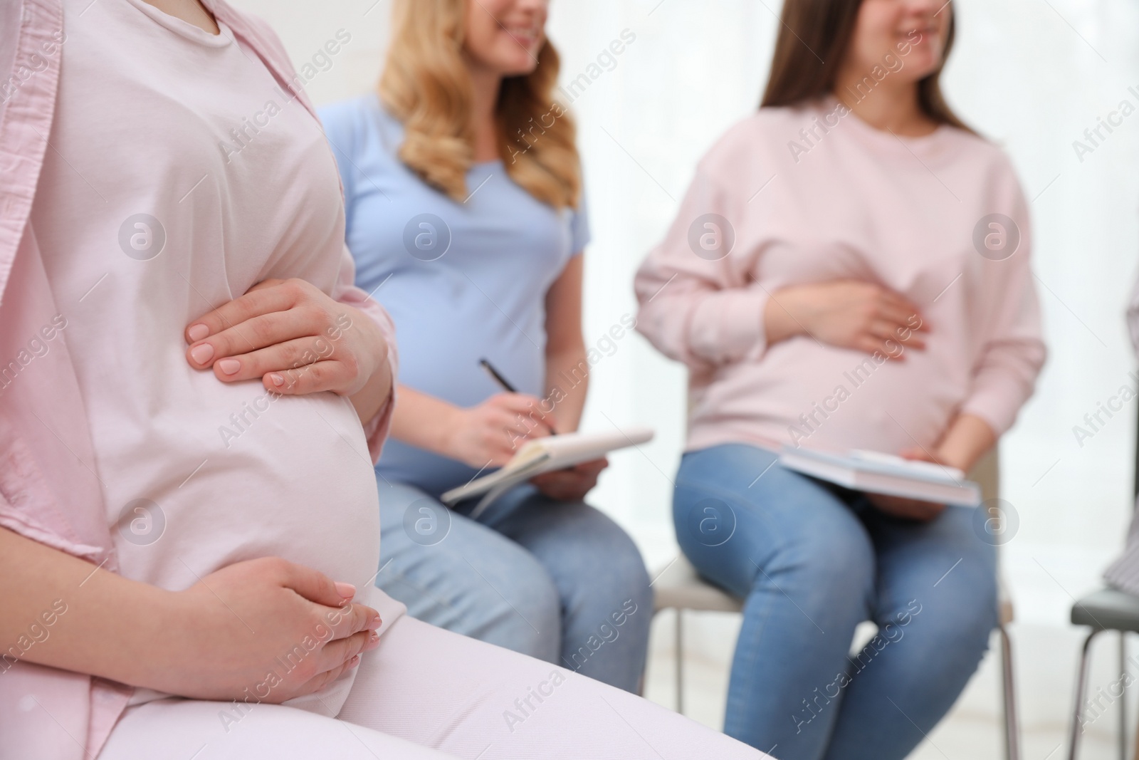 Photo of Group of pregnant women at courses for expectant mothers indoors, closeup