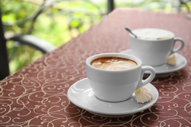 Cups of delicious aromatic coffee on table