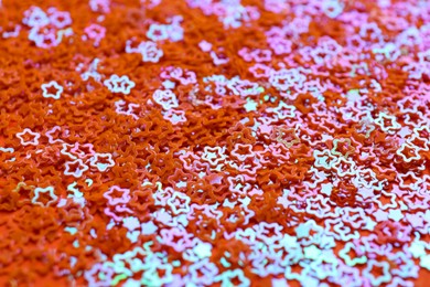 Photo of Shiny bright star shaped glitter as background, closeup view