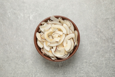 Photo of Tasty coconut chips on grey table, top view