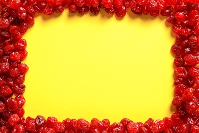 Photo of Frame made of cherries on color background, top view with space for text. Dried fruits as healthy food