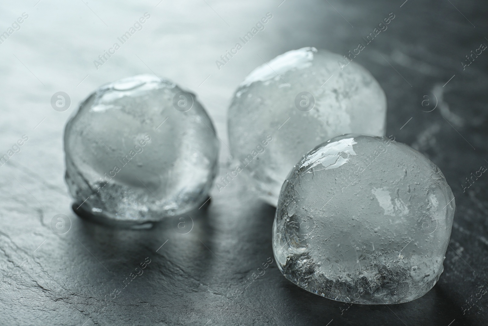 Photo of Frozen ice balls on black table, closeup