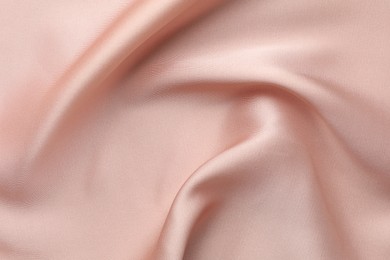 Crumpled pink silk fabric as background, top view