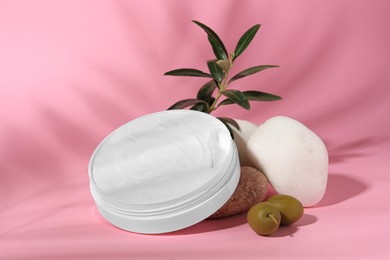 Photo of Jar of natural cream, stones and olives on pink background. Cosmetic products
