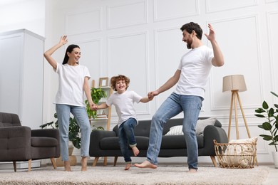 Happy family dancing in living room, low angle view