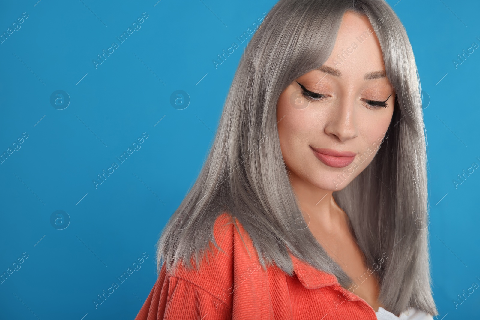 Image of Beautiful woman with ash hair color on blue background. Space for text