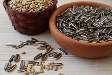 Organic sunflower seeds on white wooden table, closeup