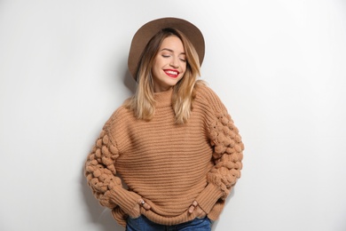 Photo of Beautiful young woman in warm sweater with hat on white background