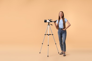 Happy astronomer with telescope on beige background, space for text