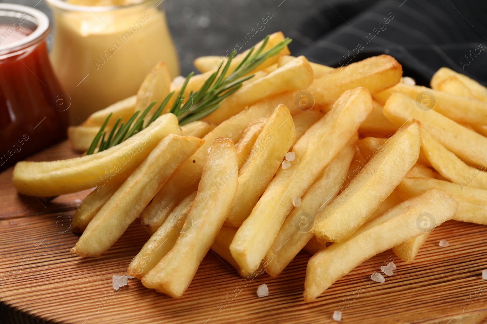 Photo of Delicious french fries with rosemary on table, closeup