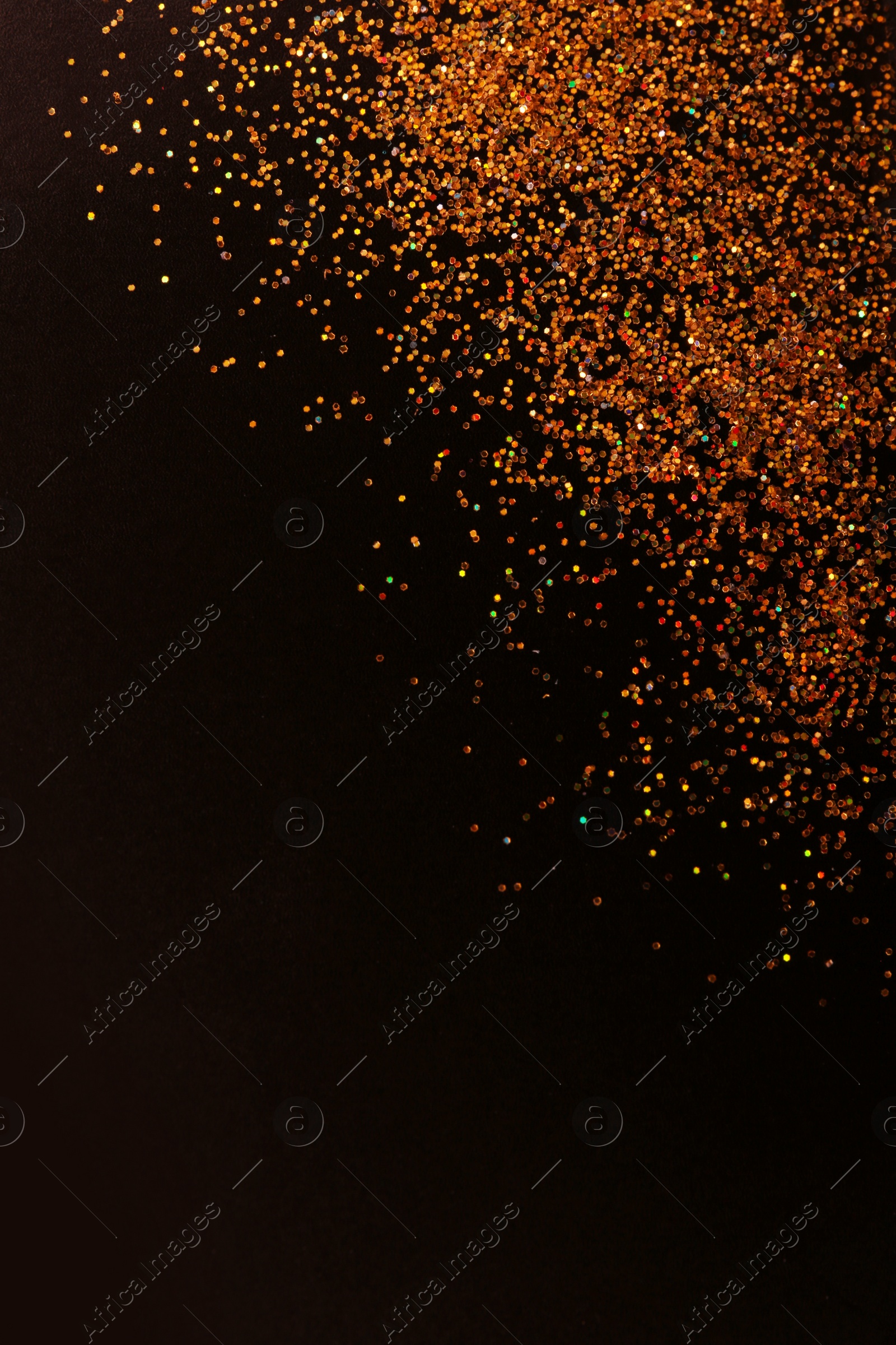 Photo of Gold glitter on black background, top view with space for text