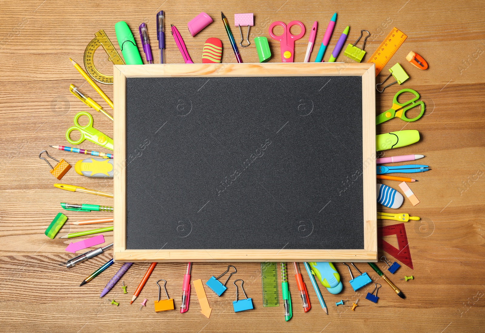 Photo of Flat lay composition with different school stationery and small chalkboard on wooden background